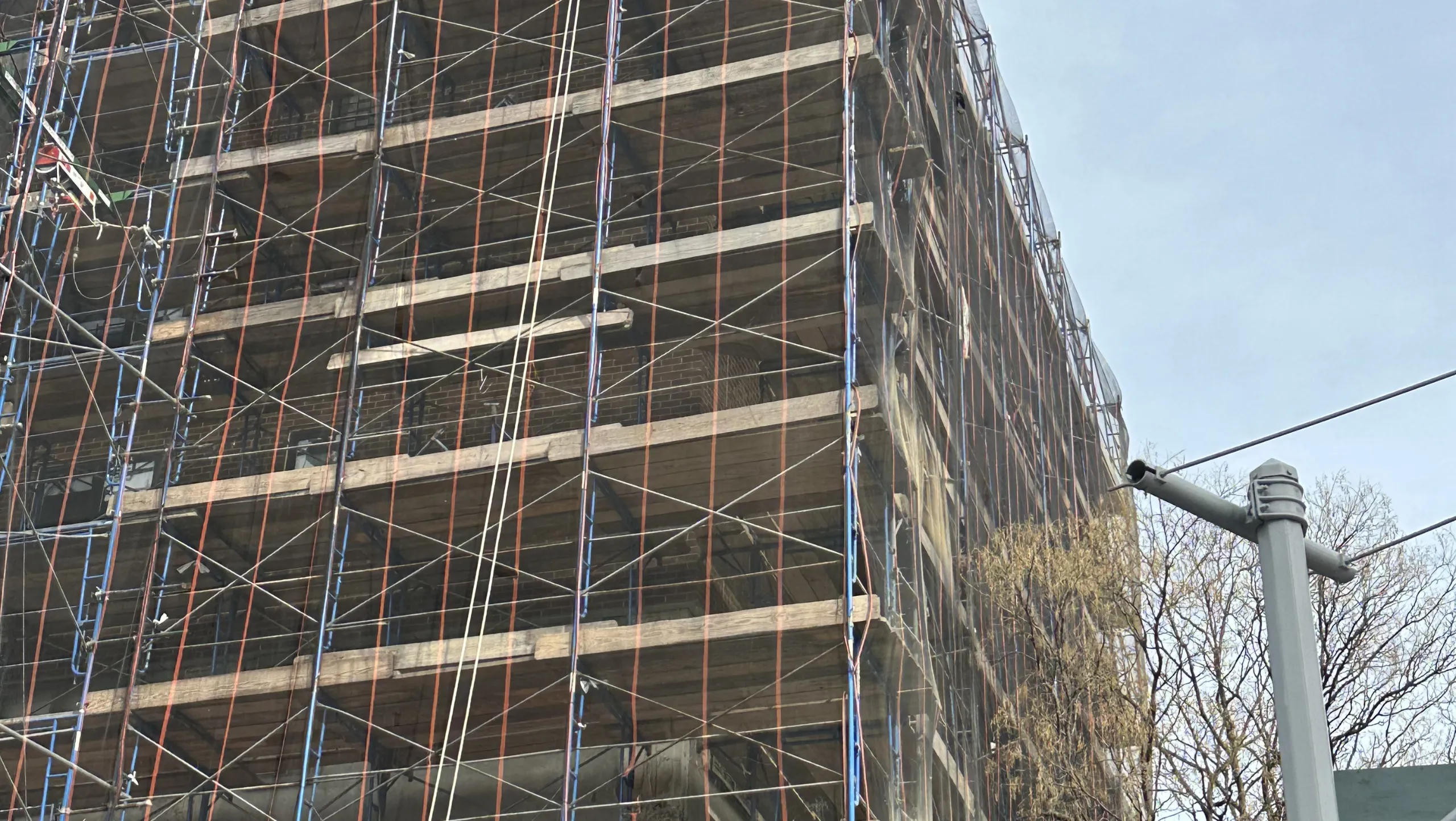 Temporary sidewalk shed structure guiding pedestrians safely past a construction zone during events in Rockville Centre